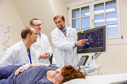 Kardiologen besprechen Ultrascahllaufnahmen einer Patientin