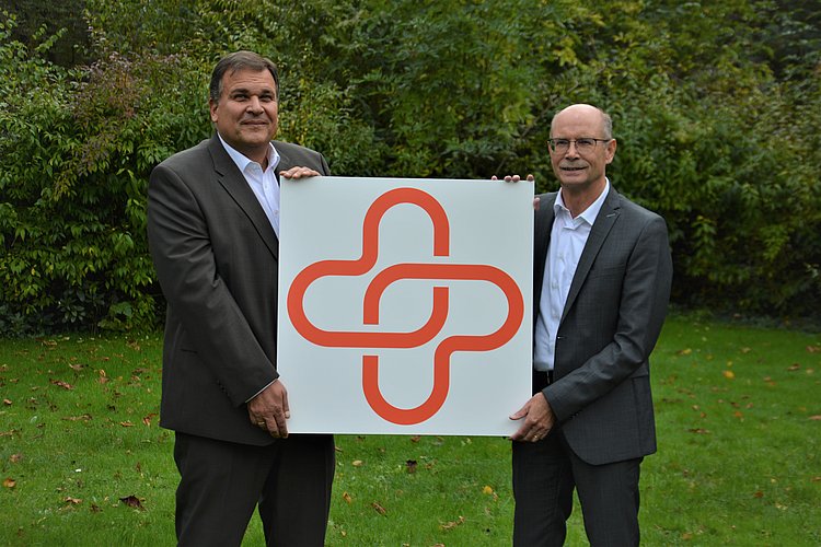Thomas Gäde und Dieter Kesper halten das neue Logo zusammen in den Händen.